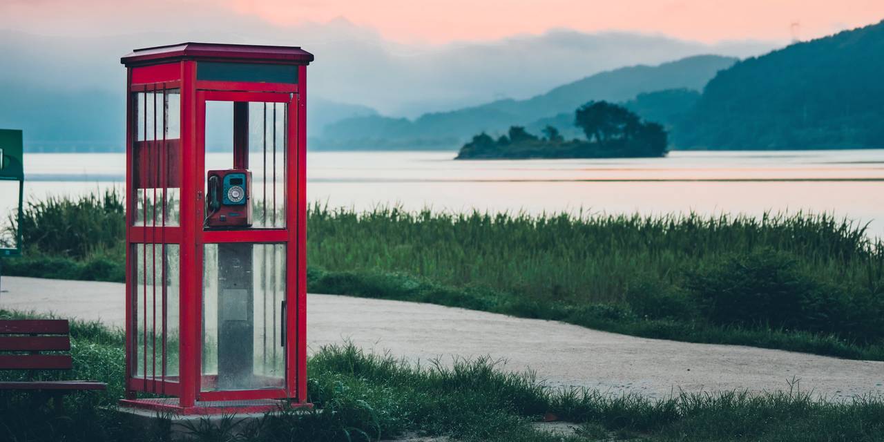 A photo of a phone booth by a lake