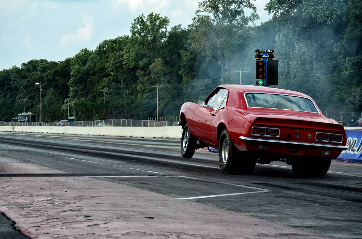 A muscle car accelerating on a drag strip